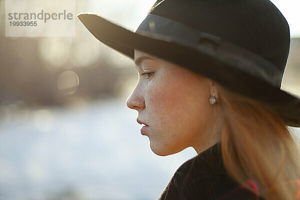 Porträt einer jungen Frau mit Hut an einem sonnigen Tag