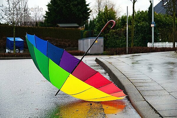 Bunter Regenschirm liegt auf der Straße