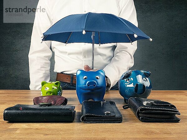 Geschäftsmann hält einen kleinen blaün Regenschirm  Schutz oder Sicherheit Konzept Bild  schützen Sie Ihre Ersparnisse