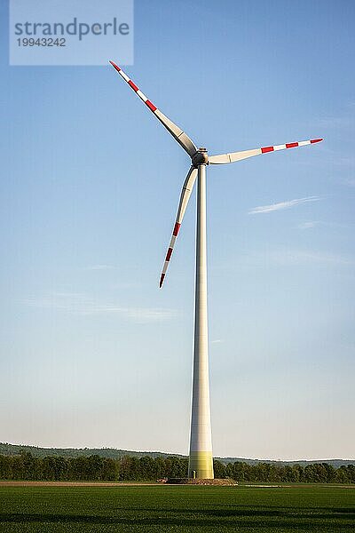 Windkraftanlagen für grüne Energie bei Sonnenuntergang mit Himmel