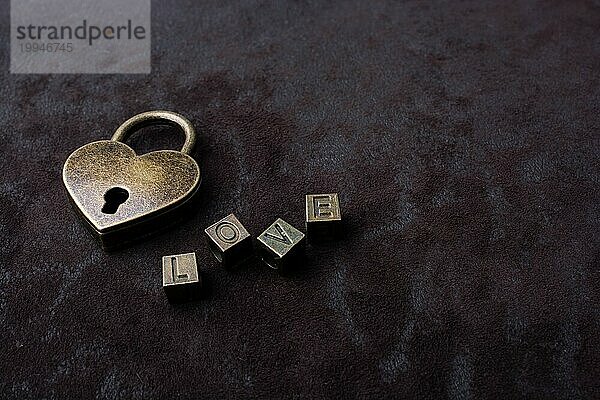 Liebe geformt Vorhängeschloss  Schlüssel und Liebe Wortlaut auf schwarzem Hintergrund