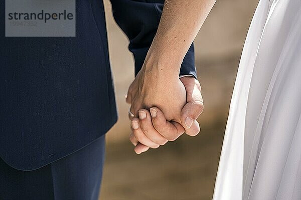 Braut und Bräutigam halten die Hände bei der Hochzeit der glücklichen Braut und Bräutigam  Ehe Porträts