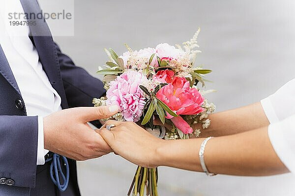 Braut und Bräutigam halten sich bei der Hochzeit an den Händen  Hochzeitsportraits