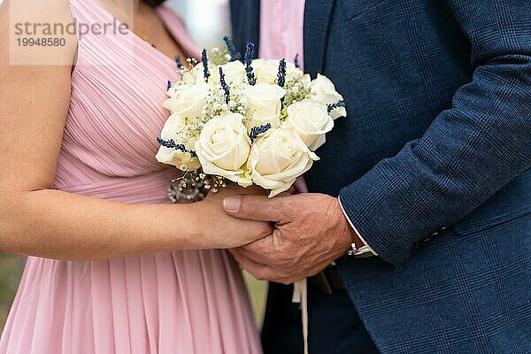 Braut und Bräutigam halten sich bei der Hochzeit an den Händen  Hochzeitsportraits