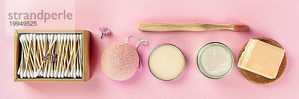 Plastikfreie  abfallfreie Kosmetika  flach gelegt auf einem rosa Hintergrund. Bambuszahnbürste Wattestäbchen  Konjac Schwamm  natürliche Bio Produkte  Panoramafoto