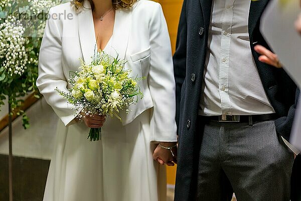 Detail von nicht erkennbaren Braut und Bräutigam  die sich bei der Hochzeit die Hände schütteln  Hochzeitsporträts