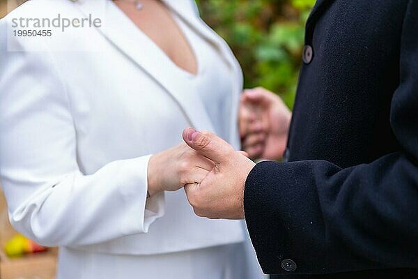 Detail von nicht erkennbaren Braut und Bräutigam  die sich bei der Hochzeit die Hände schütteln  Hochzeitsporträts