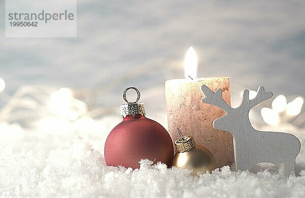 Weihnachtsdekoration im Schnee mit Kerze  selektiver Fokus auf goldene Christbaumkugel im Vordergrund  Urlaub Hintergrund