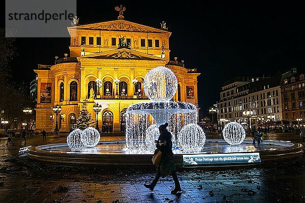 Die Silhouette einer Passantin zeichnet sich vor dem leuchtenden Weihnachtsschmuck auf dem Opernplatz an der Alten Oper in Frankfurt am Main ab.  Opernplatz  Frankfurt am Main  Hessen  Deutschland  Europa