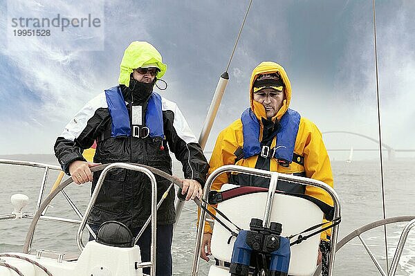 2 Männer stehen am Heck einer Segelyacht