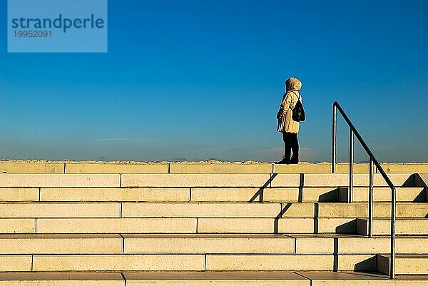 Einsame Frau auf einer Hafentreppe