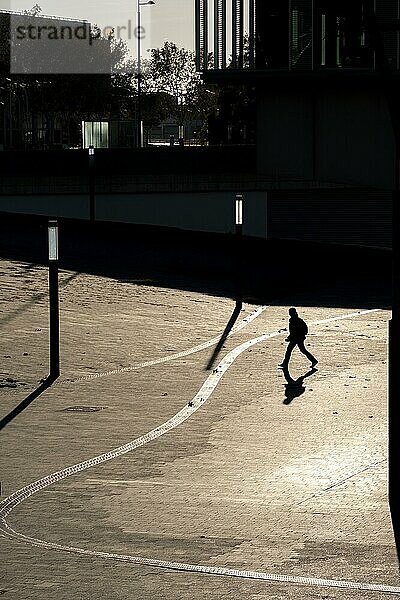 Silhouetten von Menschen  die in einem Finanzviertel in Barcelona spazieren gehen