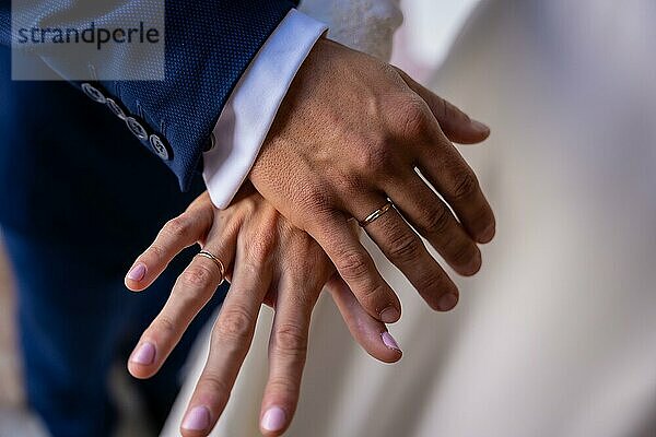 Hände von Braut und Bräutigam umarmt mit Ringen bei einer schönen Hochzeit  Trauung