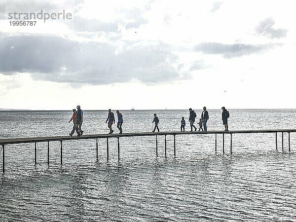 Menschen laufen auf der unendlichen Brücke . Die Brücke ist ein Kunstwerk  das für Sculpture by the Sea gebaut wurde  Aarhus  Dänemark  25.07.2023  Europa