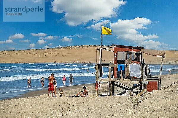 Rettungsschwimmerturm und Touristen  die am Strand von Barra de Valizas spazieren gehen  Badeort  Balneario entlang des Atlantiks  Rocha  Uruguay  Südamerika