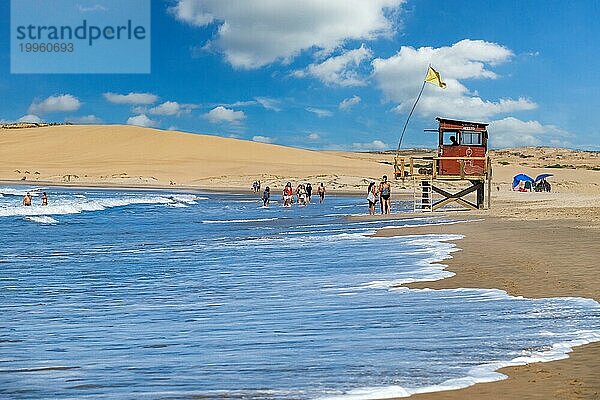 Rettungsschwimmerturm und Touristen  die am Strand von Barra de Valizas spazieren gehen  Badeort  Balneario entlang des Atlantiks  Rocha  Uruguay  Südamerika