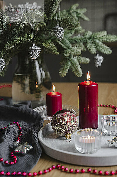 Christmas candles decoration placed on table near tree