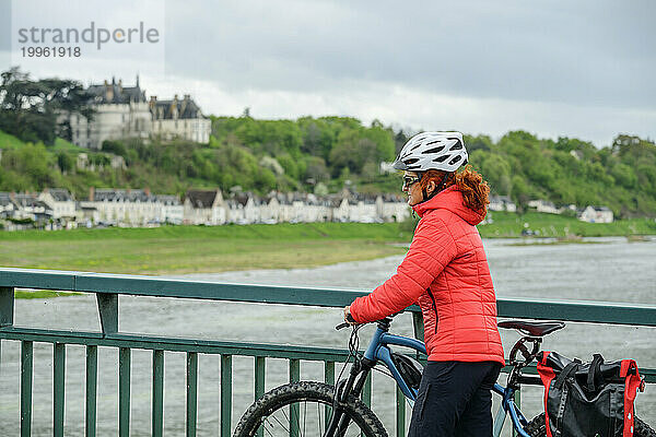 France  Centre-Val de Loire  Woman walking with bicycle across bridge over river Loire