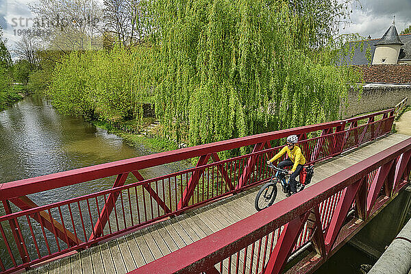 Frankreich  Centre-Val de Loire  Radfahrerin fährt über eine Brücke