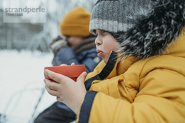 Brothers drinking tea in winter