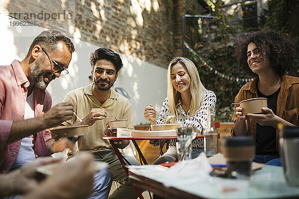 Freiwillige essen nach dem Treffen gemeinsam im Gemeinschaftsgarten