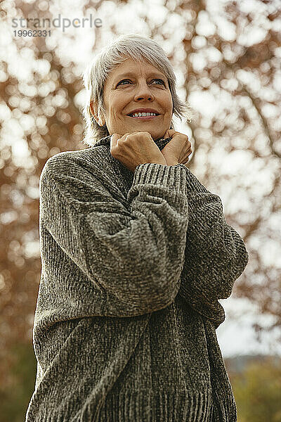 Glückliche reife Frau im grauen Pullover
