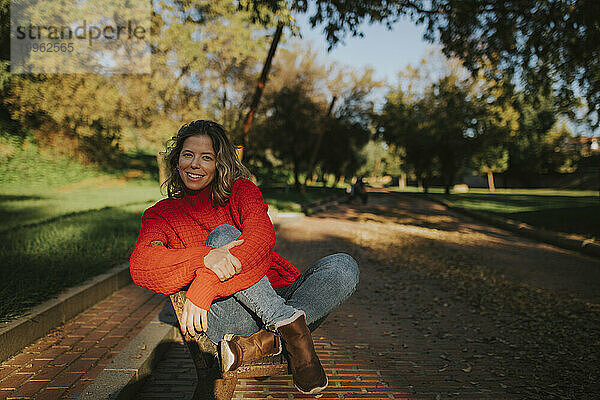 Lächelnde Frau sitzt im Park