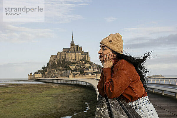 Nachdenkliche Frau steht auf einer Brücke am Schloss Saint Michel