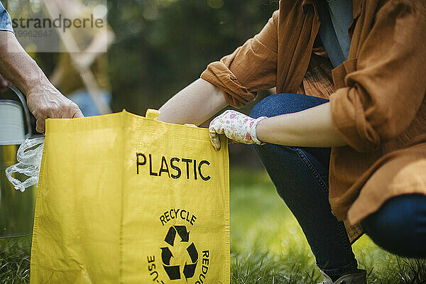 Frau stellt Plastikmüll-Recyclingbeutel ins Gespräch