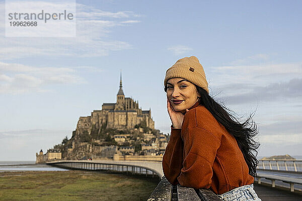 Schöne Frau mit Strickmütze steht auf der Brücke am Schloss Saint Michel