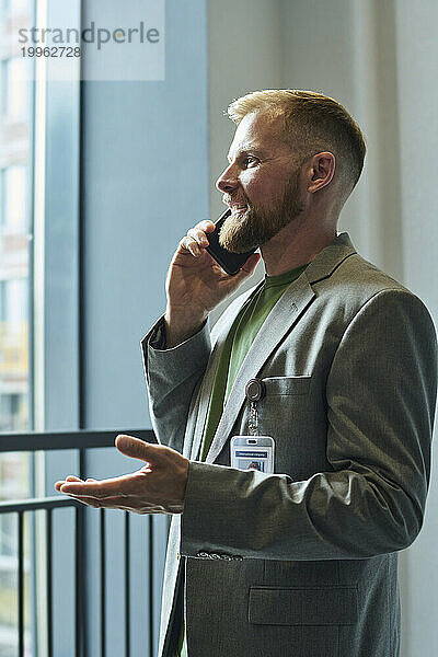 Geschäftsmann spricht im Büro mit Smartphone