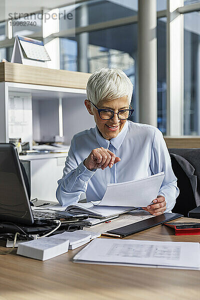 Geschäftsfrau prüft Dokument am Arbeitsplatz