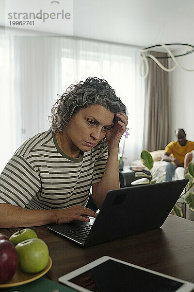 Frau benutzt Laptop und arbeitet von zu Hause aus