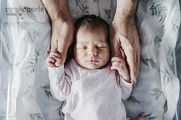 Vater hält die Hände des kleinen Mädchens
