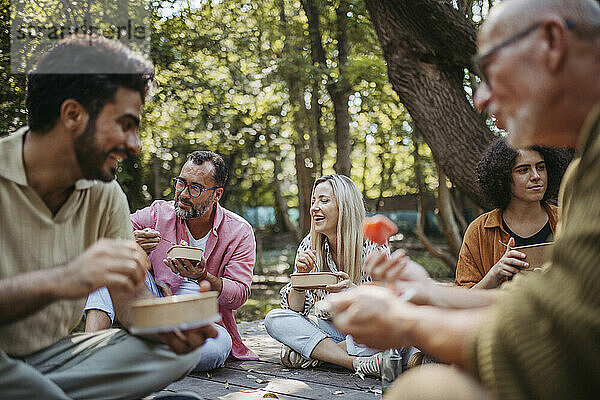 Freiwillige des Gemeinschaftsprojekts essen gemeinsam im Gemeinschaftsgarten