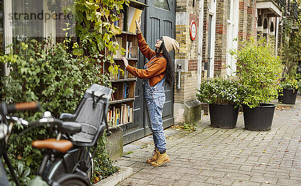 Frau greift in Buchhandlung nach Buch