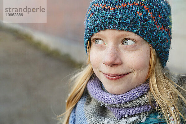 Lächelndes Mädchen mit blonden Haaren und Strickmütze