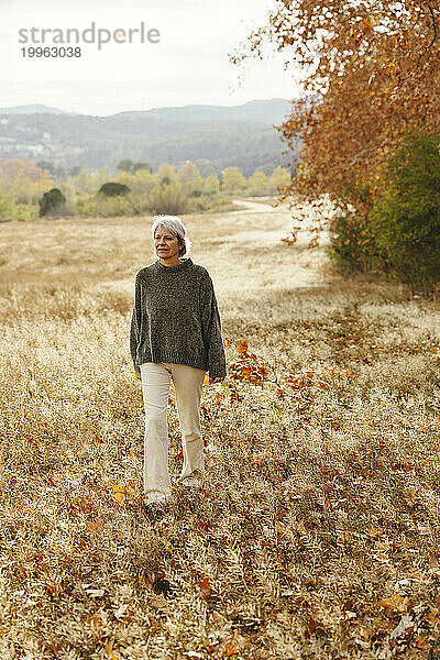 Reife Frau  die auf dem Feld läuft