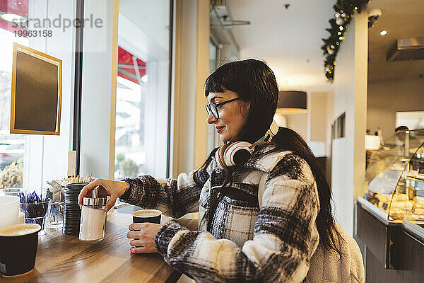 Frau trinkt Kaffee und steht im Café