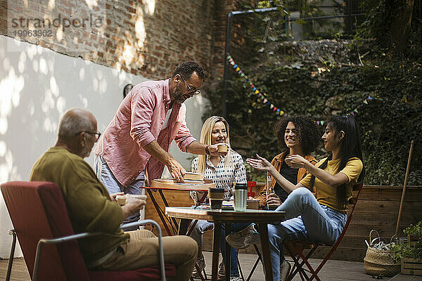 Freiwillige essen nach dem Treffen gemeinsam im Gemeinschaftsgarten