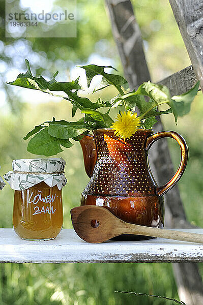 Marmeladenglas  Holzkelle und Löwenzahn im Keramikkrug