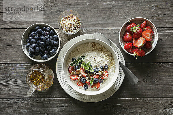 Studio shot of bowl of porridge with blueberries and strawberries