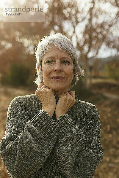 Lächelnde reife Frau mit grauen Haaren in der Natur
