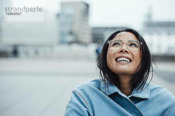 Happy businesswoman wearing eyeglasses at office park