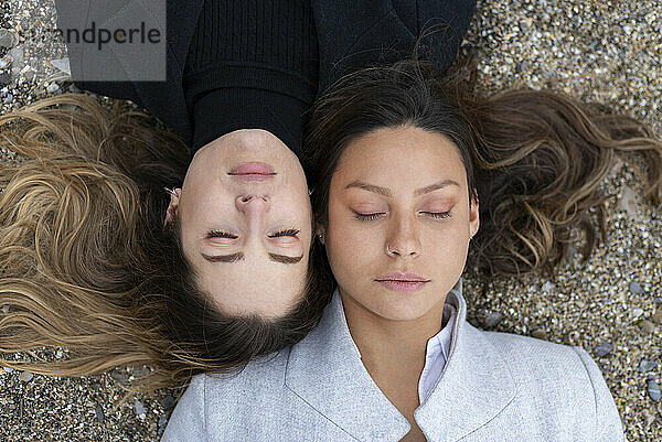 Lesbian couple lying with eyes closed