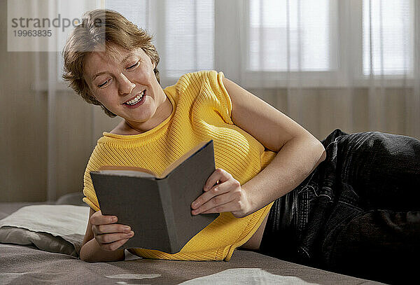 Happy woman reading book at home