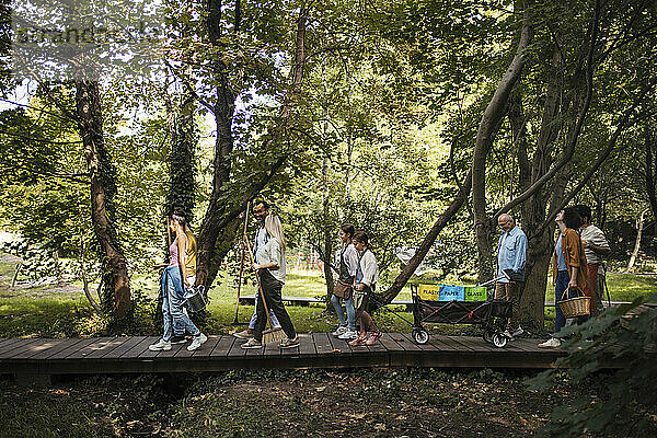 Gruppe von Freiwilligen mit Besen und Eimern  die an der Aufräumaktion im Park teilnehmen