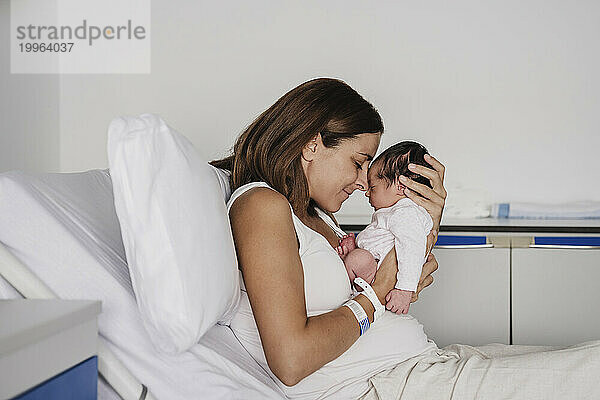 Liebevolle Mutter umarmt ihre kleine Tochter im Krankenhaus