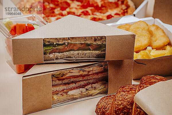 Packed sandwiches with croissant against beige background