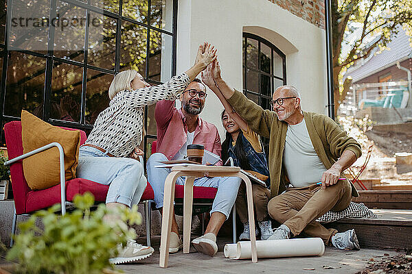 Gruppe von Leuten  die vor dem Gemeinschaftsgebäude High-Five feiern